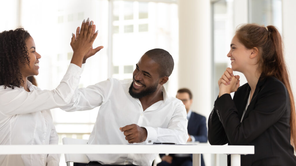 African american man giving high five woman at successful meeting.